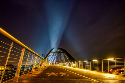 Illuminated bridge against sky at night