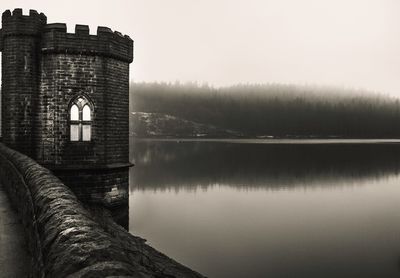 Reflection of building in lake against sky