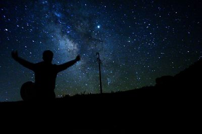 Silhouette man standing against sky at night