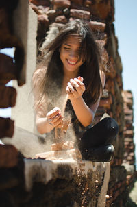 Young woman playing with sand