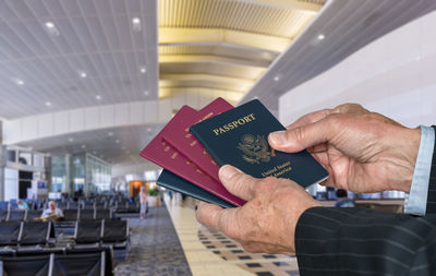 Cropped image of man holding passports at airport