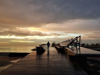 Pier over sea against sky during sunset