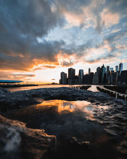 Scenic view of sea and buildings against sky during sunset