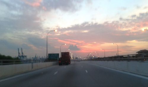 Road against cloudy sky at sunset