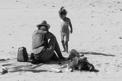 Rear view of women sitting on beach
