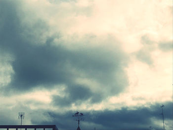 Low angle view of silhouette building against cloudy sky