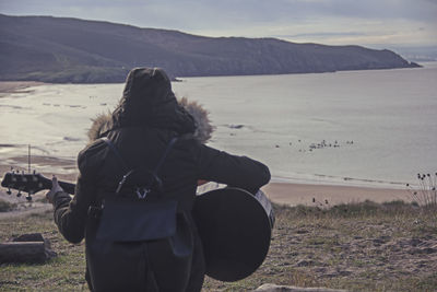 Rear view of woman standing on landscape against sky