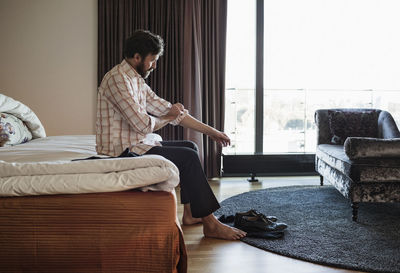 Businessman rolling up his sleeve in hotel room