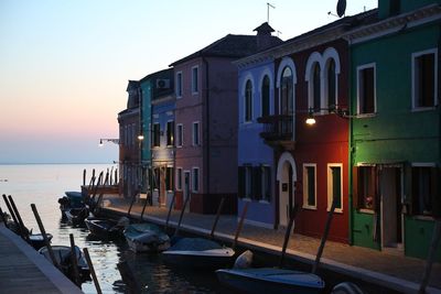 Boats in sea against sky during sunset