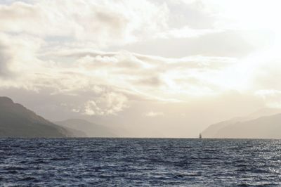 Scenic view of sea and mountains against sky