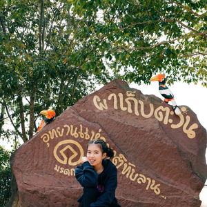 Portrait of woman with text against plants