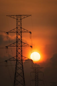 Low angle view of silhouette electricity pylon against romantic sky