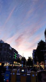 City street and buildings against sky during sunset