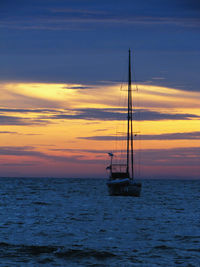 Sailboat on sea against sky during sunset