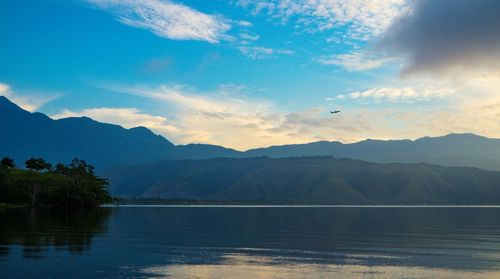 Scenic view of lake by mountains against sky