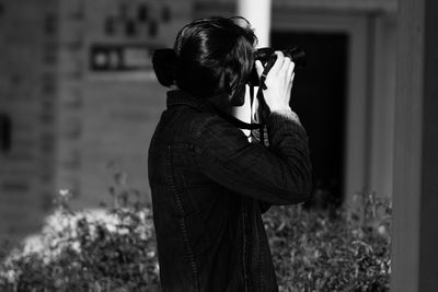 Rear view of man photographing outdoors