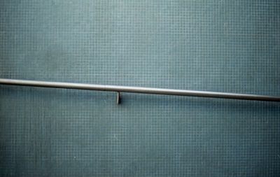 Close-up of railing against blue wall