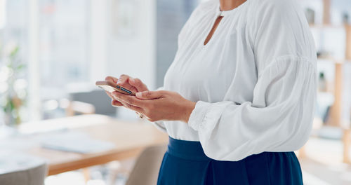 Midsection of woman using mobile phone