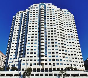 Low angle view of modern buildings against blue sky