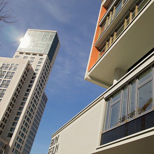 building exterior, architecture, low angle view, built structure, modern, city, office building, building, sky, skyscraper, window, glass - material, tall - high, reflection, directly below, day, residential building, tower, outdoors, cloud