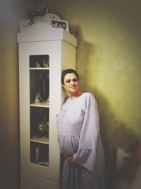 Portrait of pregnant woman standing at home