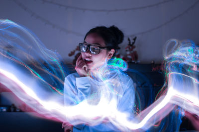 Thoughtful woman with light painting at home