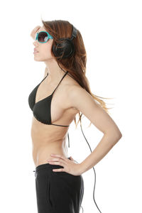 Young woman wearing sunglasses standing against white background
