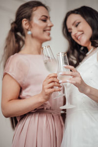 Smiling young woman drinking glass