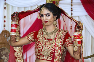 Portrait of smiling bride holding sari