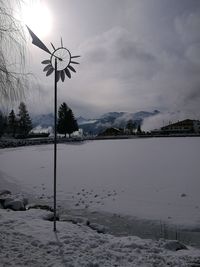 Scenic view of frozen lake by snowcapped mountains against sky