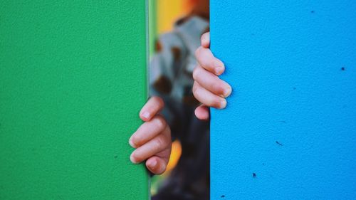 Close-up of hands touching wall