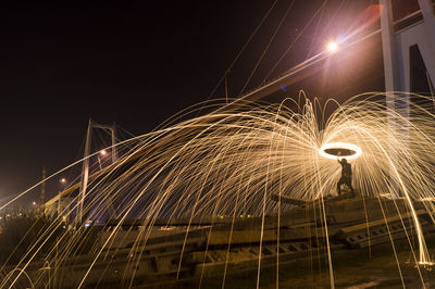 Low angle view of illuminated bridge in city at night