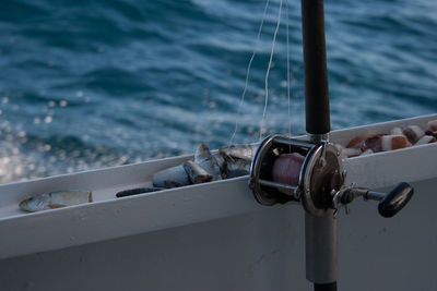 Close-up of fishing rod against sea