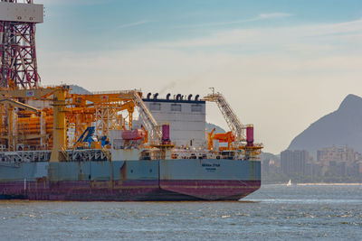 Commercial dock by sea against sky