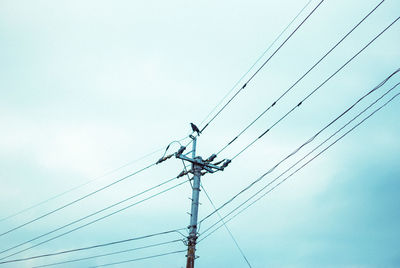 Low angle view of electricity pylon against sky