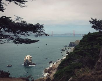 View of suspension bridge over sea against sky