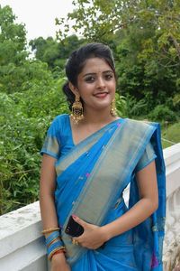 Portrait of smiling young woman standing against trees