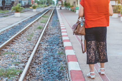 Low section of woman standing on railroad station platform
