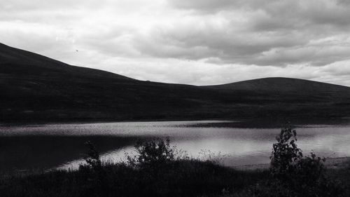 Scenic view of lake against cloudy sky