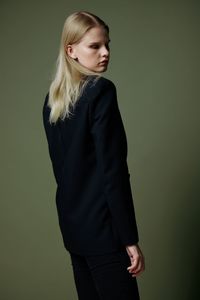 Young woman standing against gray background