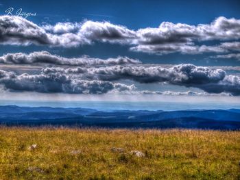 Scenic view of mountains against cloudy sky