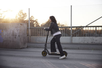 View of young woman riding scooter