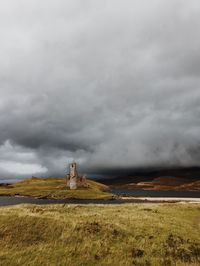 View of grassy landscape against cloudy sky