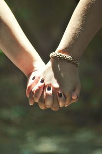 Cropped image of lesbian couple holding hands