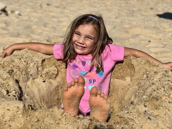 Portrait of smiling girl sitting at beach