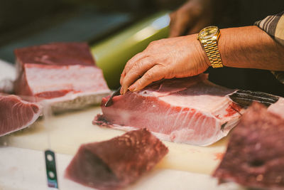 Close-up of hands cutting meat