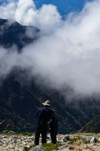 Rear view of man on mountain against sky