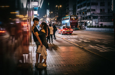 People walking on city street at night