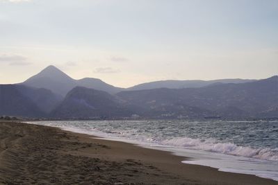 View of calm beach against mountain range
