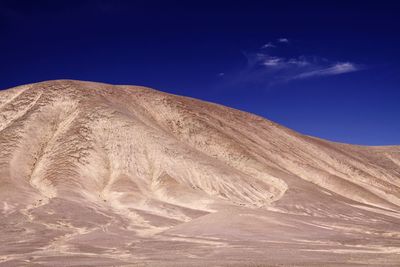 Scenic view of desert against blue sky